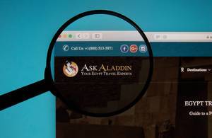 Lupe über dem Logo der Internetseite von Ask Aladdin