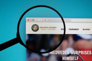 Lupe über dem Logo der Internetseite von Roland-Garros