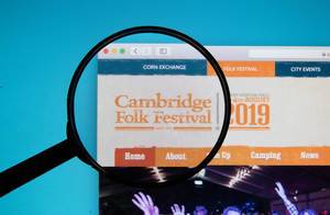 Lupe über dem Logo und Schriftzug der Internetseite des Cambridge Folk Festivals