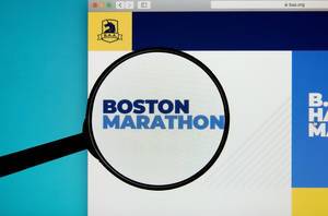 Lupe über dem Logo und Schriftzug des Boston Marathons