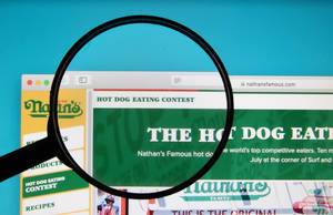 Lupe über dem  Schriftzug eines Hot Dog Essen-Wettbewerbs