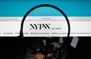 Lupe über Logo der Internetseite von NYFW, der New York Fashion Week auf PC-Bildschirm