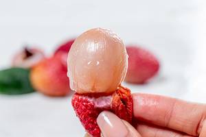 Lychee fruit pulp without peel in a woman