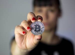 Mädchen hält silbernen Bitcoin in der Hand