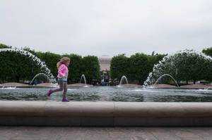 Mädchen läuft um den Springbrunnen, USA