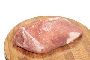 Mageres Stück ungekochtes Schweinefleisch auf hölzernem Küchenbrett vor weißem Hintergrund
