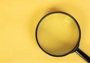 Magnifier glass on yellow background