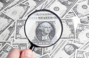 Magnifying glass on dollar banknotes