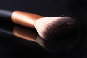 Makeup Brush above black reflective background (Flip 2019)