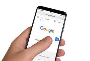 Male hands holding smartphone with an open Google website