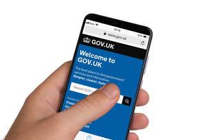Male hands holding smartphone with an open website of United Kingdom government