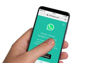 Male hands holding smartphone with an open Whatsapp application