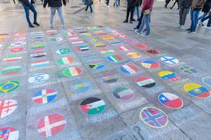 Malereien aus Kreide auf dem Boden einer Fussgängerzone  - Länderflaggen