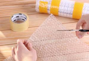 Man cutting bubble wrap with scissors