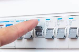 Man finger turning off the fuse on the switchboard