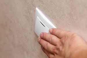 Man hand pressing button for light on wall (Flip 2019)