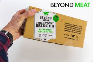 Man hold the veggie Beyond Meat Burger Box, with ten Patties, frozen packed, for a meatless, vegan diet without soy and gluten, in front of white background
