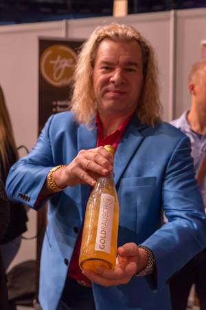 Man holding a bottle of Goldrausch golden water