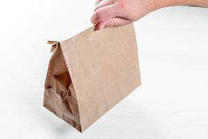 Man holding a brown paper bag in his hand