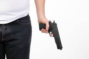 Man in jeans holding a gun