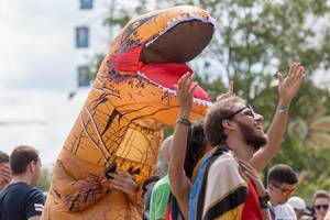 Man in orange dinosaur costum enjoys Tomorrowland festival