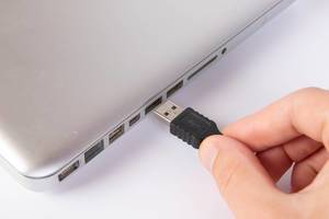 Man plugging in black USB cable