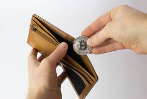 Man putting Bitcoin in his wallet
