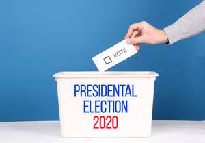 Man putting his vote in the ballot box for Presidental Election 2020