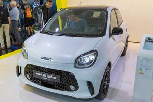 Man sits in the exhibition vehicle and tests electric mobility by Smart: EQ forfour electric car at German car show IAA
