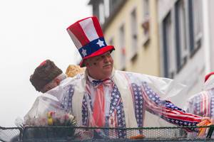 Man wearing a USA-inspired stars & stripes costume on board the satirical wagon focusing on political themes at the Rose Monday parade 2020 in Cologne