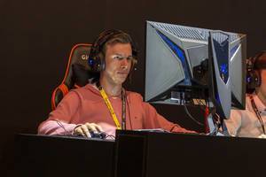 Man with AORUS headphones playing video games at Gamescom