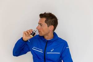 Man with blue Ascis Frontrunner jacket drinks ginger shot by "Kaltpresse"