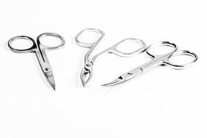 Manicure scissors and tweezers on a white background