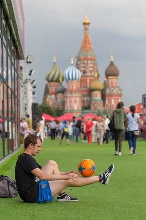 Mann balanciert einen Fußball auf seinem Bein