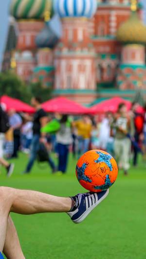 Mann balanciert Fußball auf dem Fuß