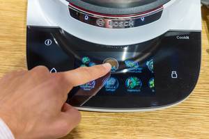 Mann benutzt die Touchscreenfunktion des Bosch Cookit Multifunktionskocher