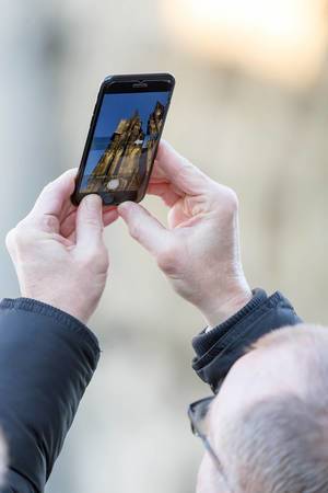 Mann fotografiert den Kölner Dom mit seinem iPhone