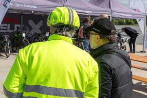 Mann in gelber Warnjacke und reflektierendem Helmschutz für eine bessere Sichtbarkeit und mehr Sicherheit beim Radfahren