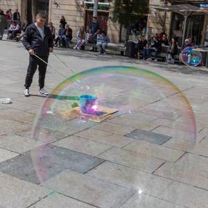 Mann macht riesige bunte Seifenblasen im Zentrum von Barcelona, Katalonien