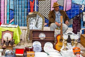 Mann mit Gitarre auf Flohmarkt Feira da Ladra