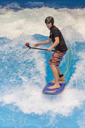 Mann mit GoPro auf Stelfiestick und Helm surft auf stehender Welle