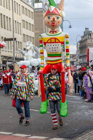 Mann mit riesiger, bunter Holzpuppe auf den Schultern - Kölner Karneval 2018