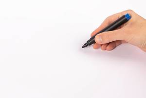Mann schreibt mit einem blauen Edding-Stift auf weißem Papier