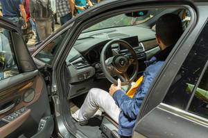 Mann sitzt im BMW Auto 225xe Active Tourer, Hybridwagen mit Allradantrieb aus der 2er Reihe