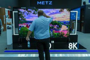 Mann steht vor dem Metz 120 Zoll 8K LCD-Fernseher mit 3m Bildschirmdiagonale