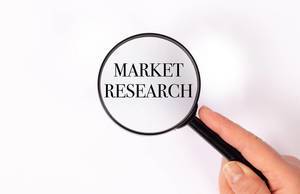 Market research unter der Lupe auf weißem Hintergrund