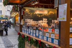 Marktstand verkauft weihnachtliche Leckereien wie gebrannte Mandeln und Magenbrot