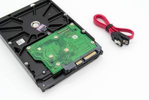 Mechanical hard disk drive with SATA cable on white background