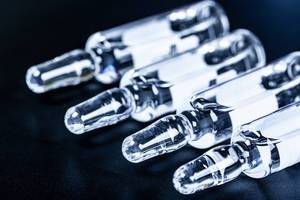 Medical ampoules with medicine on black background