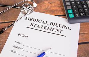 Medical billing statement with stethoscope and calculator